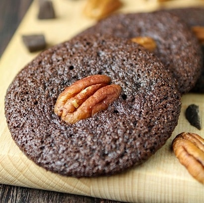 cookies tout chocolat aux noix de pécan sur une planche à découper en bois